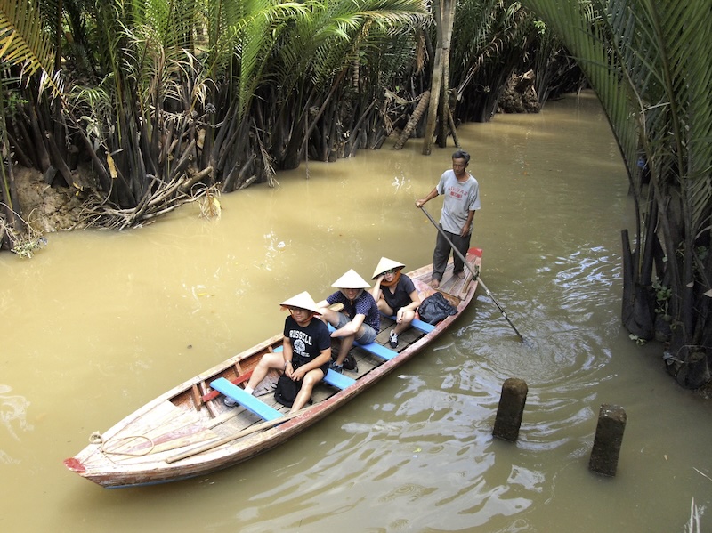 A sampan boat ride through a narrow canal in the Mekong Delta