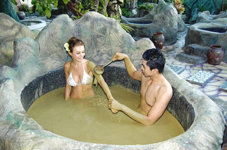 People relaxing in a therapeutic mineral mud bath in Nha Trang