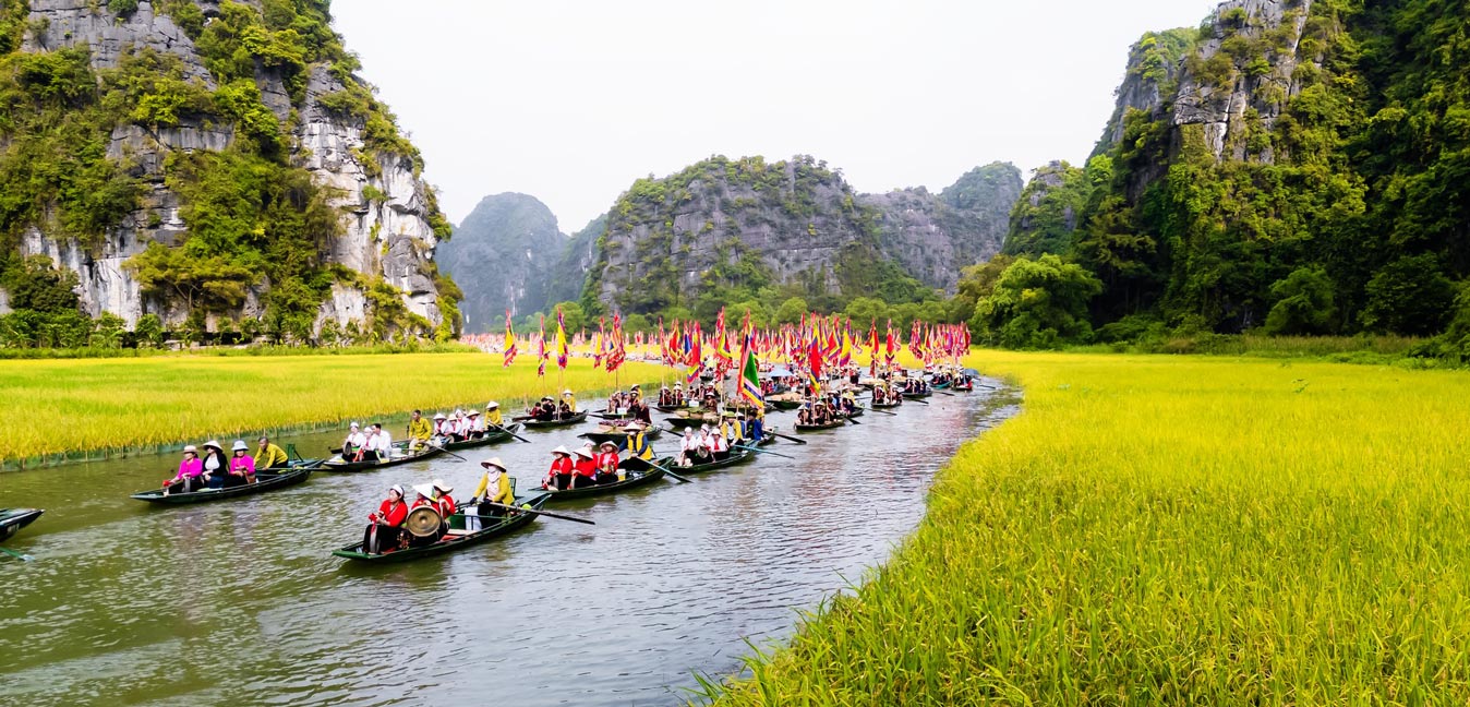 A stunning panoramic view of a boat on the river in Trang An, Ninh Binh